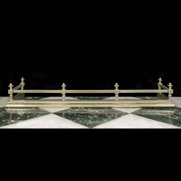 An antique brass railed fireplace fender