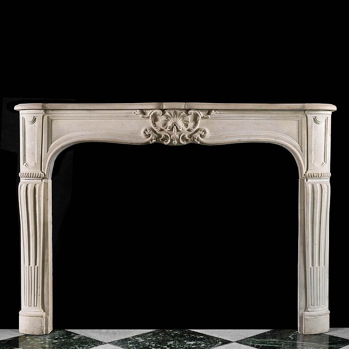 An antique Rococo style limestone fireplace surround in the Louis XV manner 