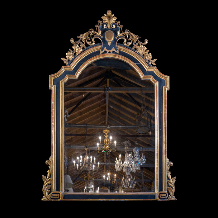 A boldly carved Spanish parcel gilt and ebonised overmantle mirror